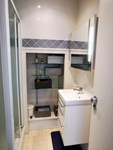 une petite salle de bain avec un lavabo et un miroir dans l'établissement Le petit Bois en bord de mer - accès animations, commerce et plage, à Argelès-sur-Mer