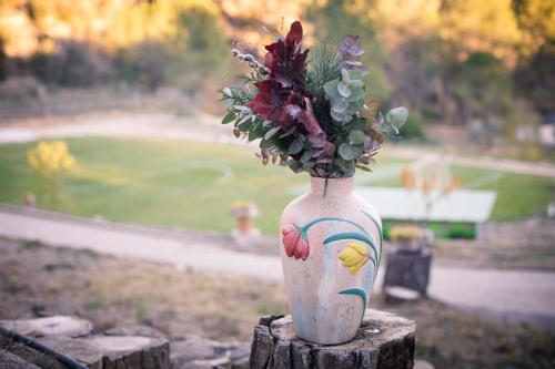 a vase with flowers in it sitting on a stump at VILLA CHETRUS Casa en plena naturaleza in Barcelona