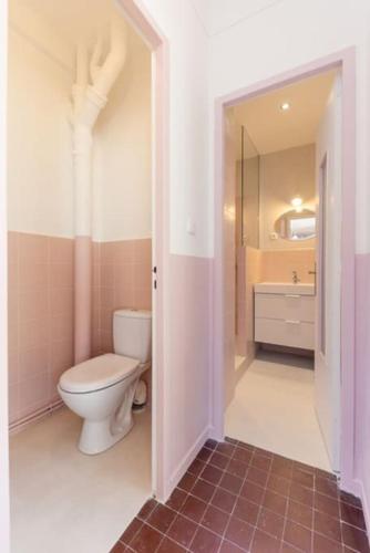 une salle de bain avec des toilettes blanches et un lavabo dans l'établissement Grand Appart Rétro Vieux-Port Panier Mucem, à Marseille
