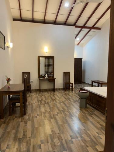 a room with two beds and a table and chairs at Sunrise oasis retreat in Habarana