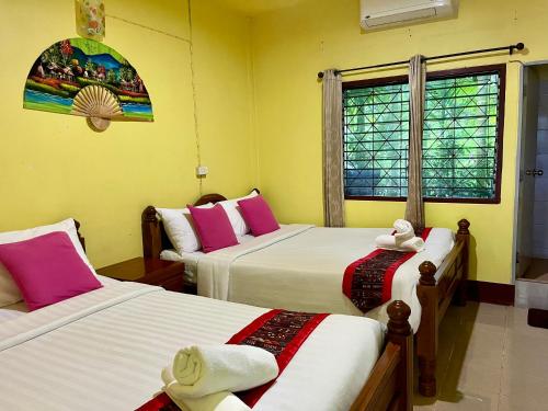 a room with two beds and a window at Khao Chang View Resort in Phangnga