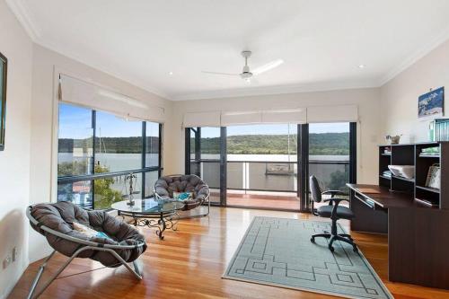 a living room with a desk and chairs and a table at Waterfront, Deep Water Pontoon, views to Straddie in Russell Island