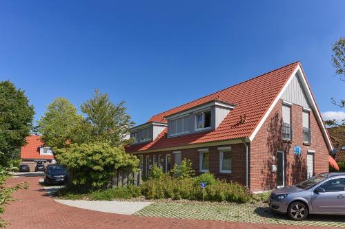 ベンサージールにあるFerienhaus Lachmöwe - Uns Huus an t Küstの前に車が駐車されている家
