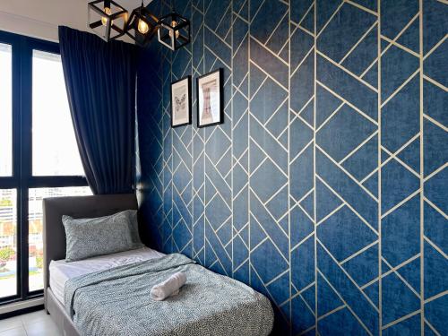 a bedroom with a blue wall with a geometric wallpaper at Cozy & Drive Urban Suite by WL in Jelutong
