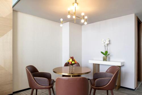 a dining room with a table and chairs at Rixos Gulf Hotel Doha in Doha