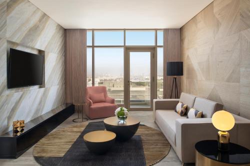 a living room with a couch and a chair at Rixos Gulf Hotel Doha in Doha