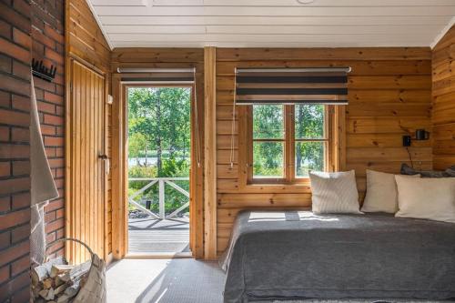 1 dormitorio con 1 cama en una pared de madera en Cottage Charm - Cozy Getaway in the Archipelago, en Naantali