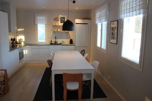 cocina con mesa blanca y sillas en Cottage Charm - Cozy Getaway in the Archipelago en Naantali