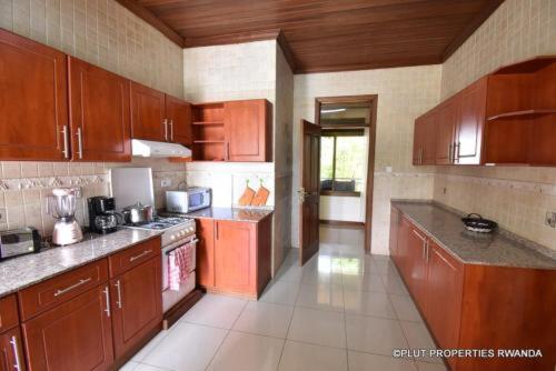 a large kitchen with wooden cabinets and appliances at KARIBA SUN BEACH APARTMENT in Rutsiro