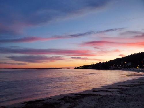 a view of a beach at sunset with the ocean at Yuca in Vallauris