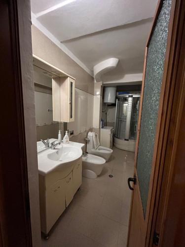 a bathroom with two toilets and a sink and a toilet istg at APARTMENT Toxhi in Shkodër