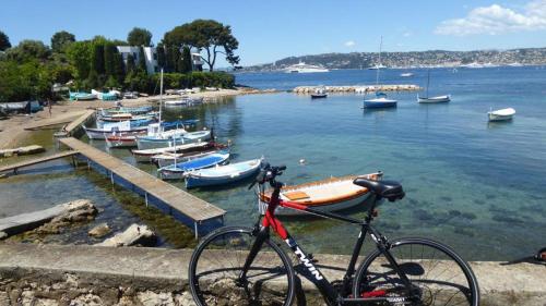 a bike parked next to a body of water with boats at Yuca in Vallauris
