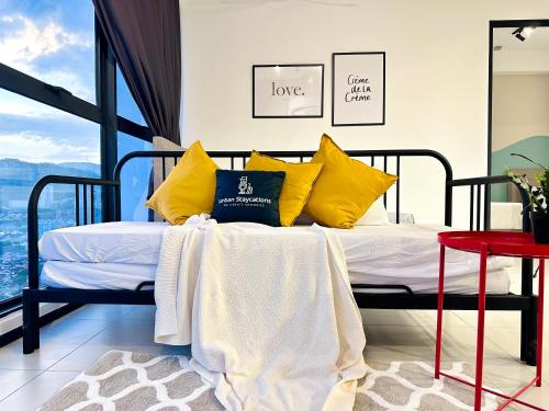 a bedroom with a bed with yellow pillows at Cozy & Drive Urban Suite by WL in Jelutong