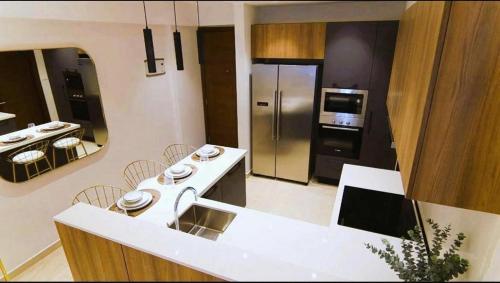 a kitchen with a white counter and a stainless steel refrigerator at Primahem solaris in Accra