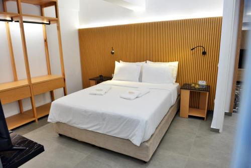 a bedroom with a large bed with white sheets and pillows at Aikaterini Lever Du Soleil in Koskinou