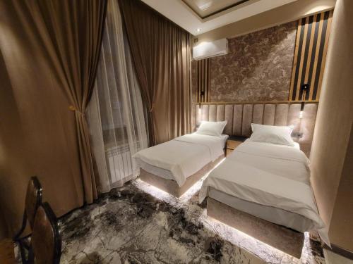ein Hotelzimmer mit 2 Betten und einem Fenster in der Unterkunft Homy House Hotel in Taschkent