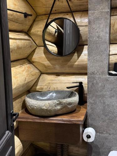 a bathroom with a stone sink and a mirror at Rtanj Kopaonik Eco Resort & Spa in Kopaonik