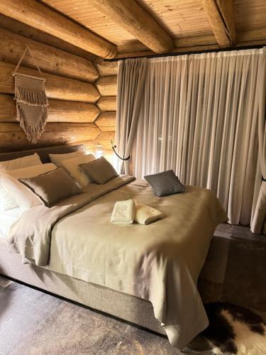ein Schlafzimmer mit einem großen Bett in einem Blockhaus in der Unterkunft Rtanj Kopaonik Eco Resort & Spa in Kopaonik
