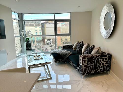 a living room with a couch and a glass table at Superior Apartment In Cardiff City Centre in Cardiff