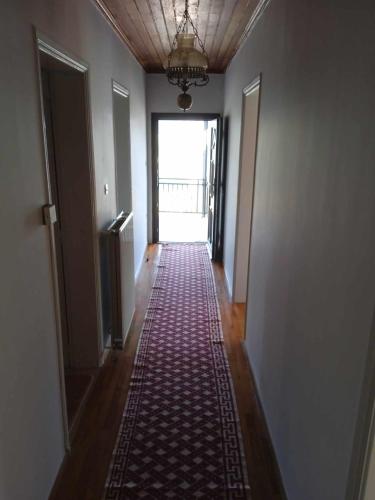 a hallway with a red rug on the floor and a door at Kria Vrisi in Anthochórion