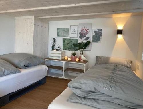 a bedroom with two beds and a table with plants at Tinyhouse Wald(t)raum in Wilhelmsthal