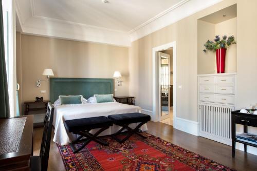 a bedroom with a large bed and a red rug at Hotel Francia E Quirinale in Montecatini Terme