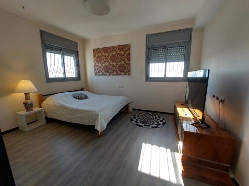 um quarto com uma cama e duas janelas em Open-space apartment by the SEA em Asdode