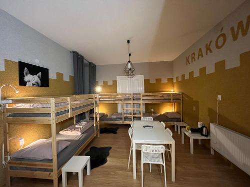 クラクフにあるGirls Hostelの二段ベッド、テーブル、椅子が備わる客室です。