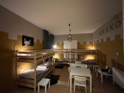 a room with bunk beds and a table and chairs at Girls Hostel in Krakow