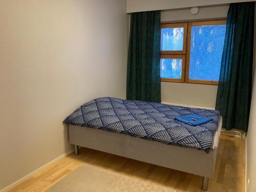a small bed in a room with a window at RovaniemiApartment 2 bedroom, livingroom, sauna in Rovaniemi