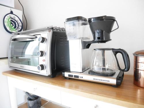 a microwave and a coffee maker on a counter at Cozy Hilltop Cottage With Fantastic View in Undenäs