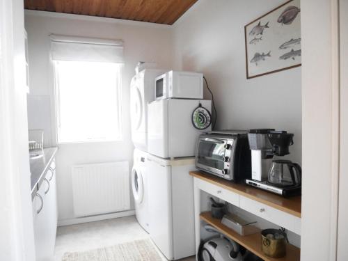a kitchen with a white refrigerator and a microwave at Cozy Hilltop Cottage With Fantastic View in Undenäs