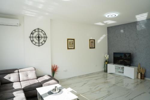 a living room with a couch and a tv at Apartment Una Laguna in Bihać
