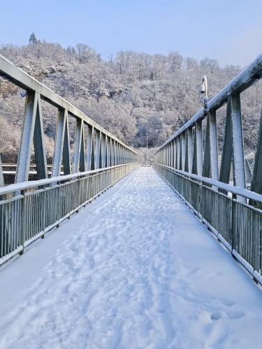 a bridge covered in snow with trees in the background at Séchoir_28 in Hastière-par-delà