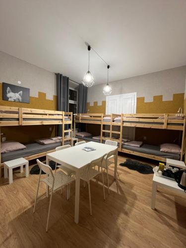 a room with bunk beds and a table and chairs at Girls Hostel in Krakow
