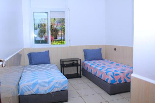 1 Schlafzimmer mit 2 Betten und einem Fenster in der Unterkunft MOHAMMEDIA 88 in Mohammedia