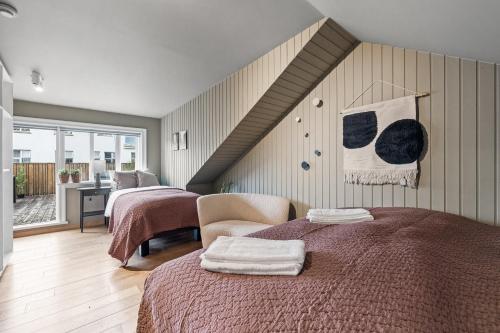 1 dormitorio con 2 camas y escalera en Venture Vacations-Massive Villa in Downtown Reykjavík with a Sauna, en Reikiavik