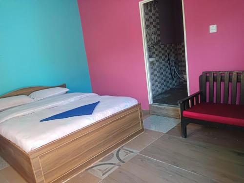 um quarto com uma cama e uma cadeira vermelha em Hotel crunchy em Deorāli
