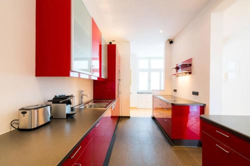 een keuken met rode kasten en een aanrecht bij Vienna Residence Althanstraße - Alsergrund 6348 in Wenen