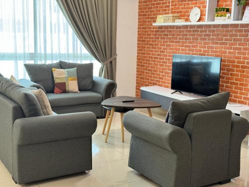 a living room with two chairs and a television at De Home Desaru Harmonia 5GWiFi Netflix BBQ 41OK7 in Bandar Penawar