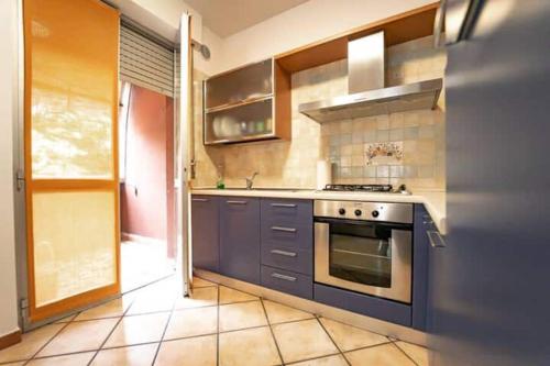 een keuken met blauwe kasten en een fornuis bij Trilocale comodo ai servizi in Alessandria