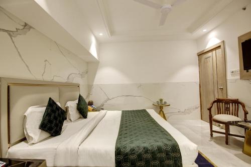 a bedroom with a large bed with a green blanket at Hotel International Inn - Near Delhi Airport in New Delhi
