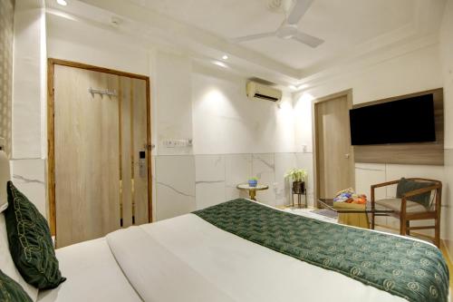 a bedroom with a bed and a flat screen tv at Hotel International Inn - Near Delhi Airport in New Delhi