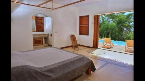 a bedroom with a bed and a view of a pool at Villa Agay in Nosy Be