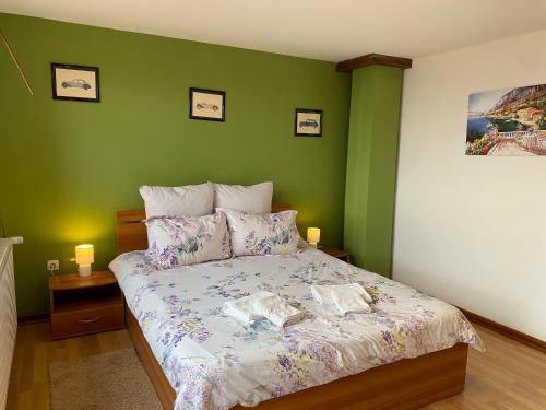 a bedroom with a bed with a green wall at Casa Genesini in Miercurea-Ciuc