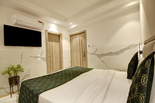 a bedroom with a large bed and a television at Hotel International Inn - Near Delhi Airport in New Delhi