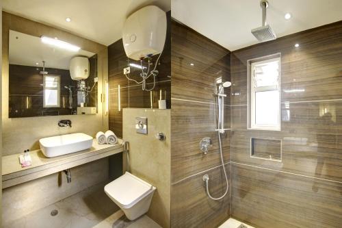 a bathroom with a toilet and a sink and a shower at Hotel International Inn - Near Delhi Airport in New Delhi