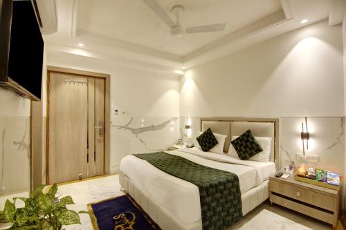 a bedroom with a large bed and a television at Hotel International Inn - Near Delhi Airport in New Delhi