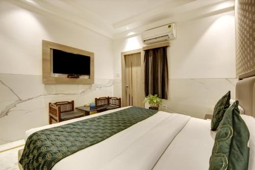 a hotel room with a bed and a tv at Hotel International Inn - Near Delhi Airport in New Delhi