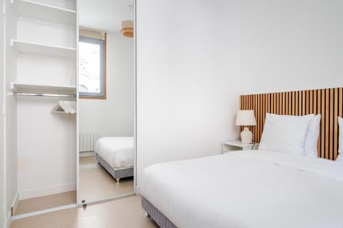 a bedroom with a bed and a mirror at Spacious apartments for 6 people #3 in Asnières-sur-Seine